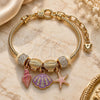 Oro Laminado Charm Bracelet, Gold Filled Style Shell and Star Design, with White Crystal, Pink Enamel Finish, Golden Finish, 03.442.0002.07 (Thickness, 7 Inches Length)